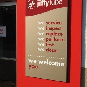 Cartel de servicios de Jiffy Lube en taller automotriz.